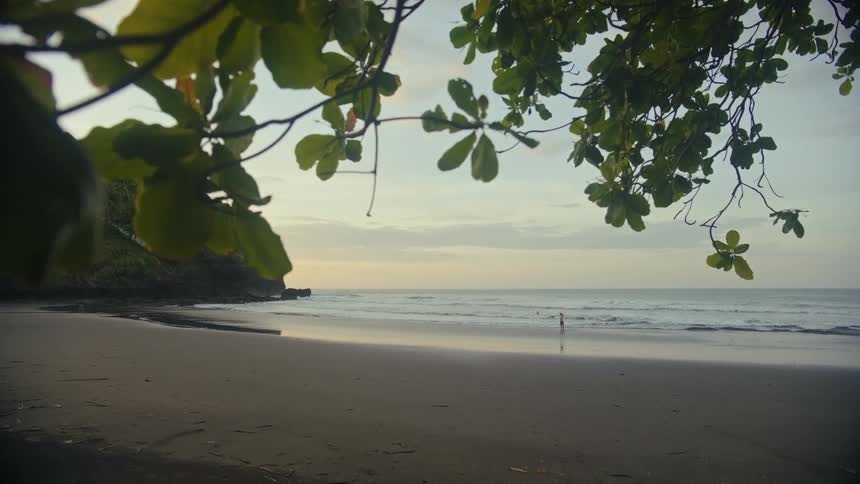 Child walks on the beach on a cloudy day