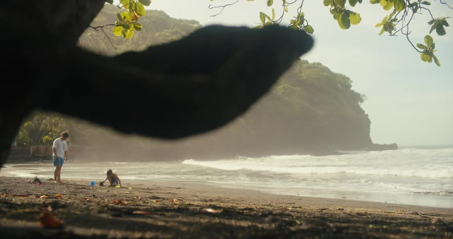 Father watches his children play on the beach on a foggy day