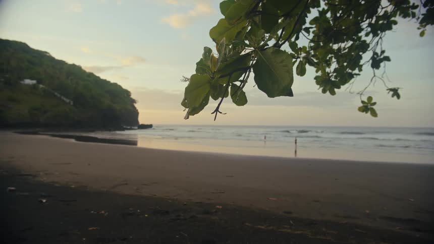 A peaceful beach shoreline at dusk next to the ocean
