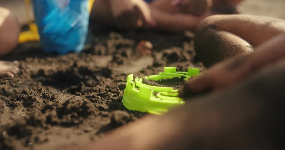 Children dig and play with dirt while sitting outside on a summer day