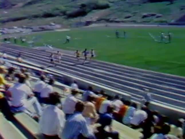 People sit in the stands to watch a track meet