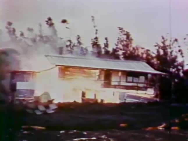 A house is on fire in the distance