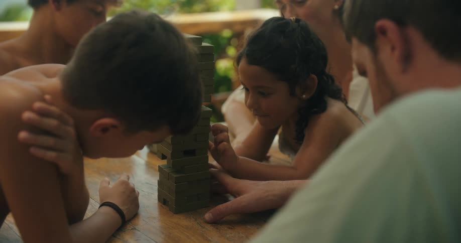 Happy family playing board game together on a vacation outdoors