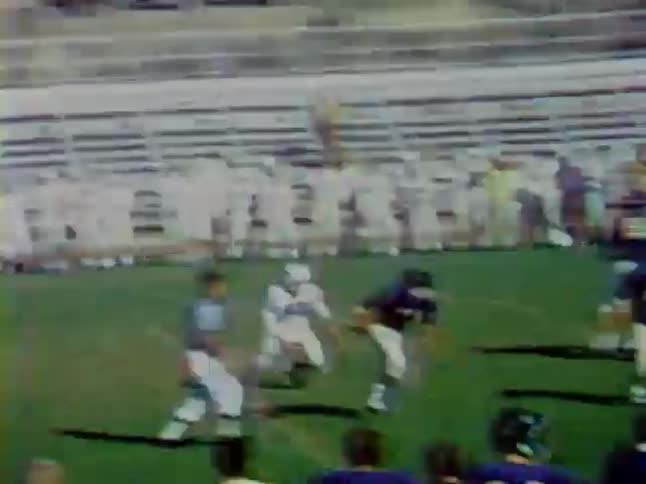 Football players run down the field moving the ball forward