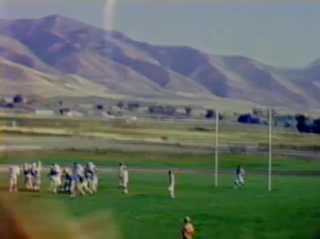 People cheer on to football players on the field