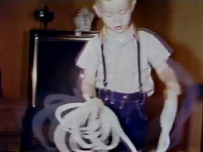 A young boy unwinds a bunch of rope