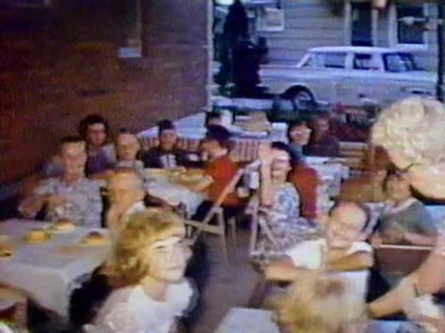 A group of children wave to the camera at a party
