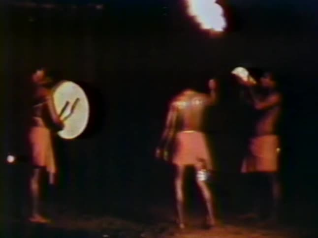 People are performing on stage with fire and drums