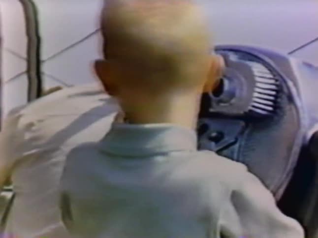 A boy looks through a telescope on a roof