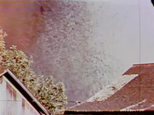 Lava sprays in the air past these homes