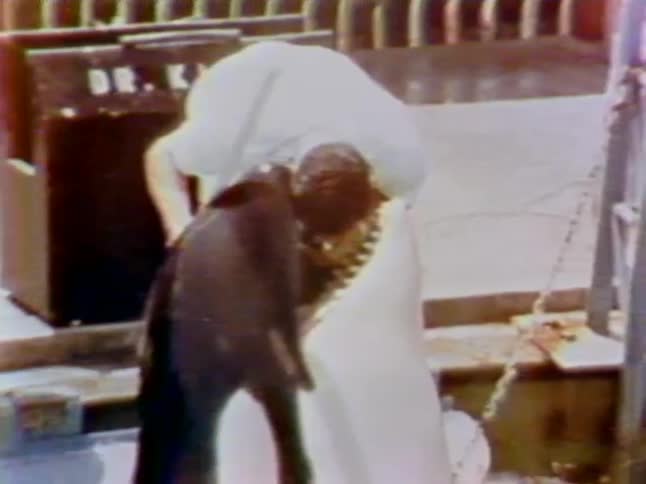 A whale bites a man's head lightly