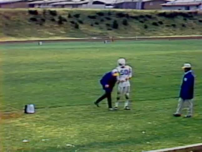 A football player is being coached on the field