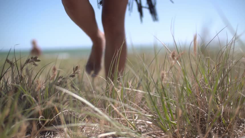 Two people on a large field, one is walking forward