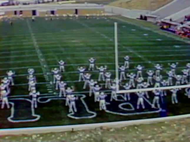 Football players doing calisthenics on the field together