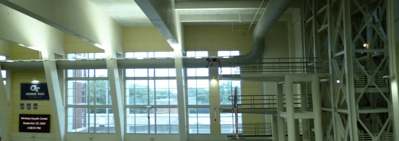 The woman does a flip off the diving platform