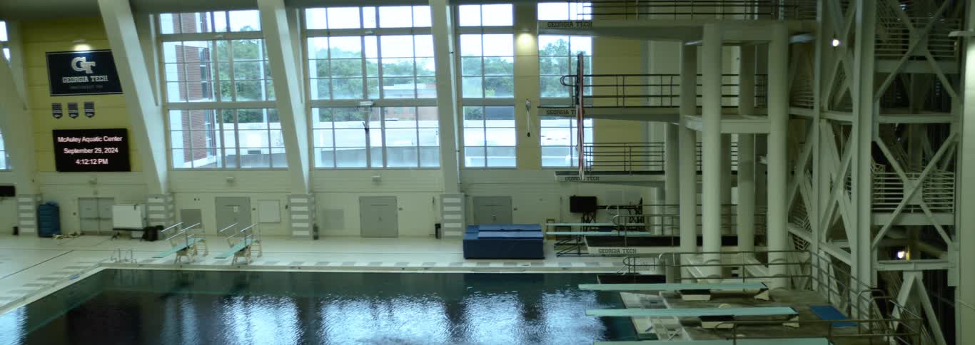 A large room with a swimming pool and a high dive
