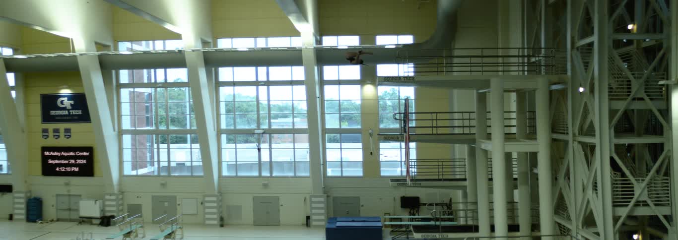 Athlete performs a somersault from a diving platform at the mcauley aquatic center