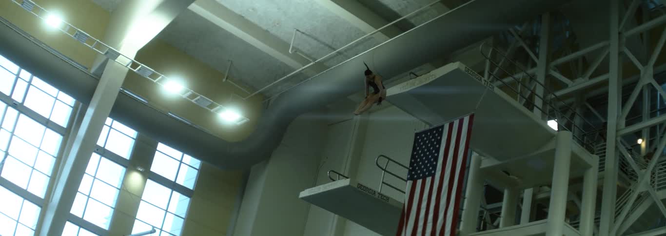 An athlete jumping from a trampoline into the pool and doing acrobatics