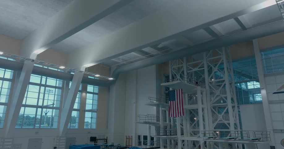 Indoor olympic pool at georgia tech with diving platforms and a hanging united states flag