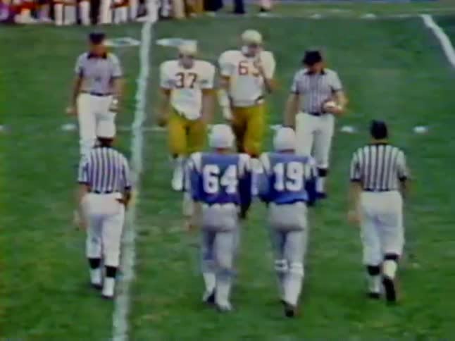 Referees and football players walking onto field