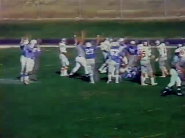Football players complete a play on the field