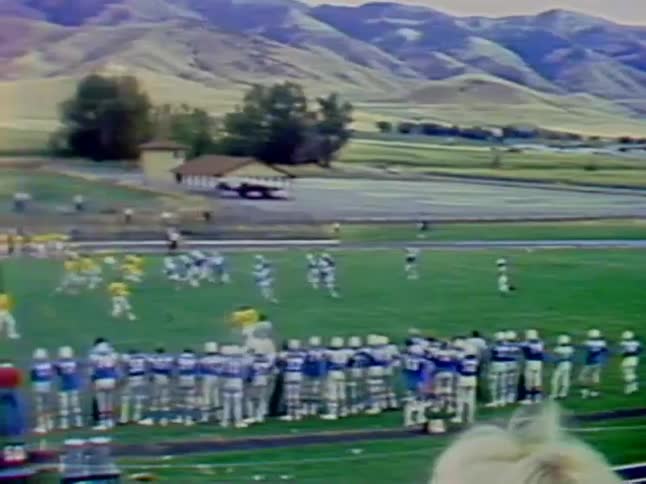 One football team kicks the ball away as the other team catches the ball