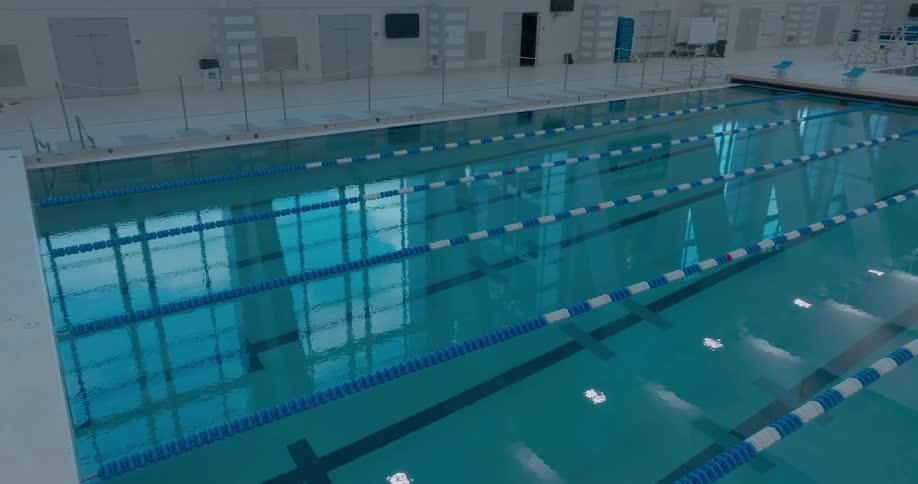 A massive indoor sports swimming pool facility at midday