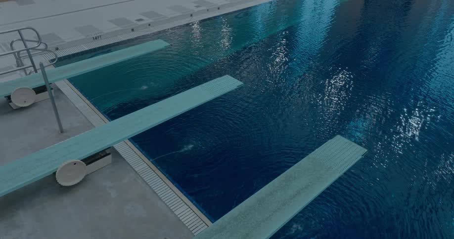 An indoor swimming pool with three diving boards and a ripple effect on the water