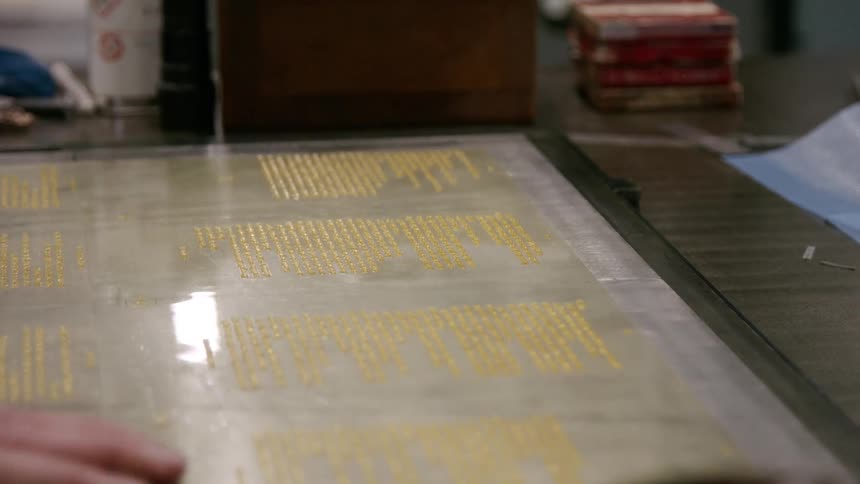 The man checks the typeset for the printing machine