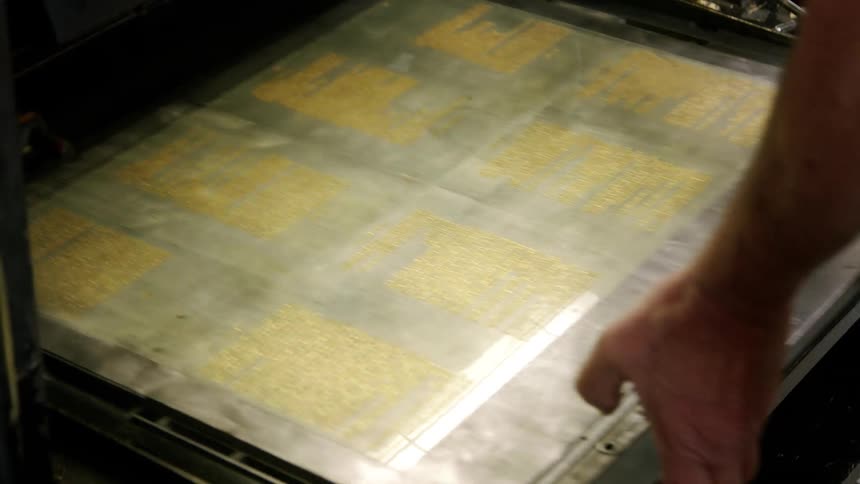 Metal printing plates with golden text being prepared for use