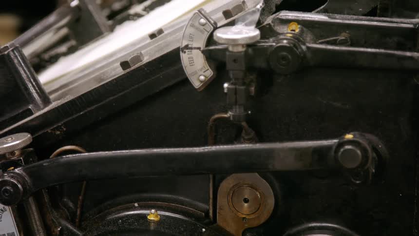 Closeup details of machinery in operation inside a printing press