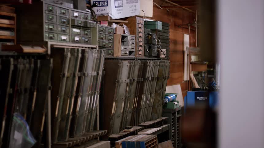 A cluttered workshop lined with metal drawers and shelves packed with parts