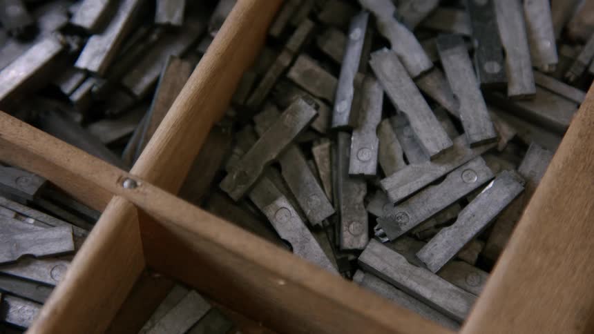 A bunch of spare metal bits in a wooden drawer
