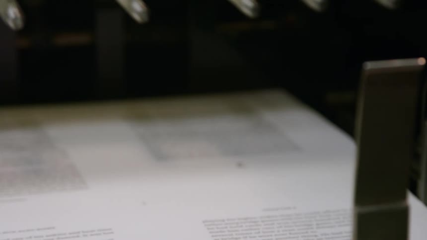 Close up of an electronic printing machine releasing printed publication pages