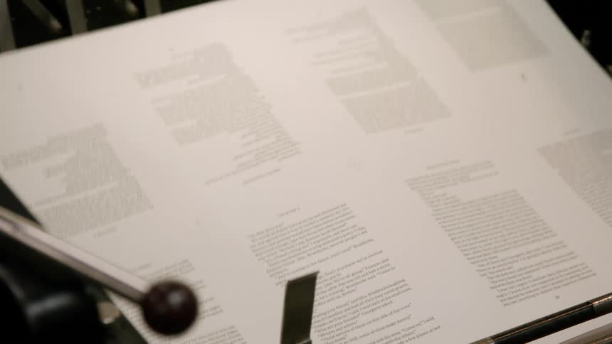 A mechanical printing press produces multiple sheets of paper