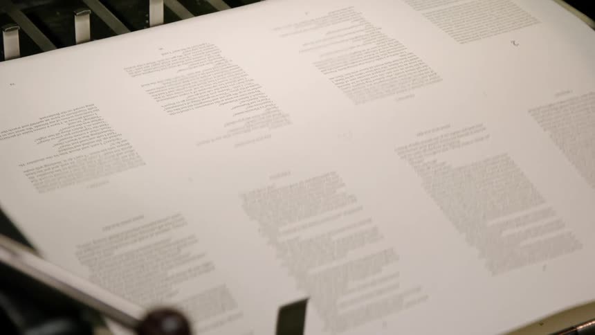 Partially visible printed sheet coming out of a printing machine