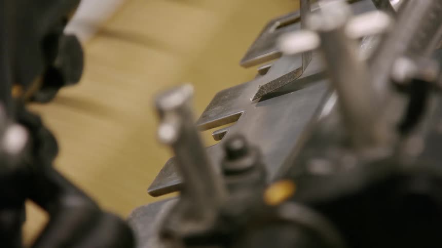 Close view of moving industrial machinery shows interlocking parts and metal components in motion