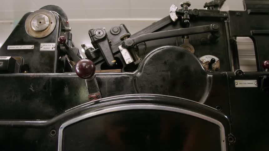 The man pulls the lever on the printing press