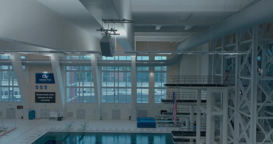 The diver walks out on the diving platform above the pool