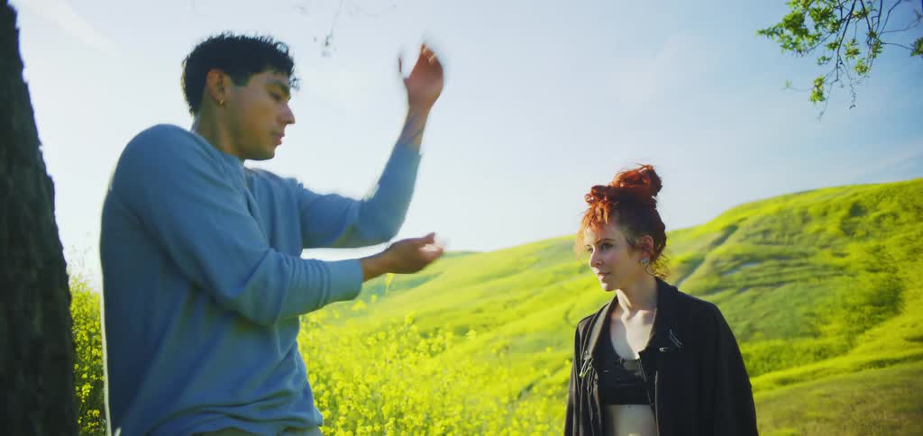 The woman smiles while watching a man do tai chi
