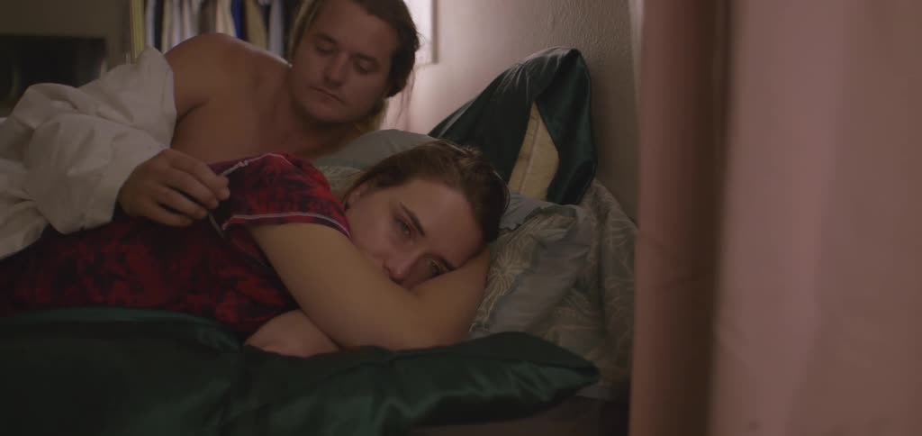 A couple have an uncomfortable moment as they lie in a bed