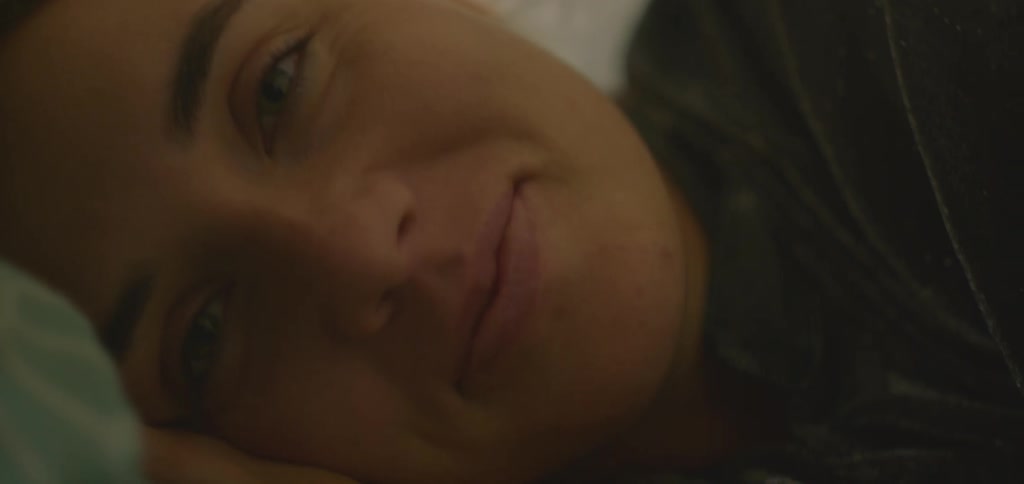 The woman smiles while laying down
