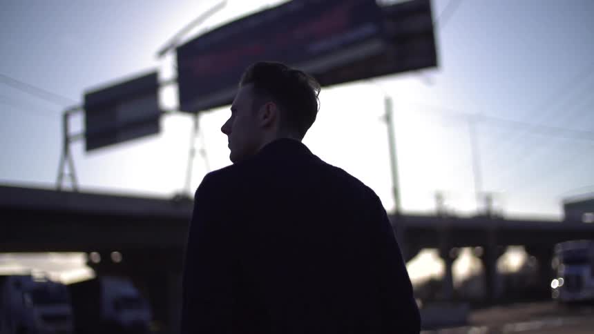 Man walks towards a concrete platform with a large sign on top