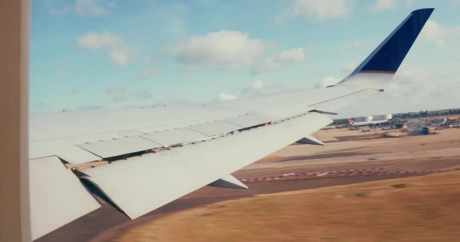 Interior view from aircraft window of the wing during take off from airport