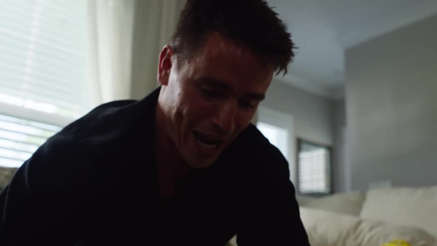Father tickling his sons in the living room