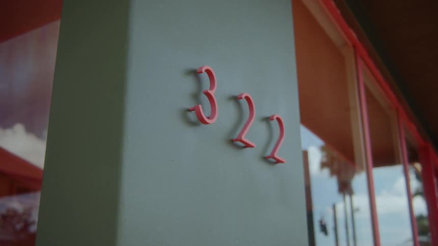 Address of a business mounted on gray wall next to the windows
