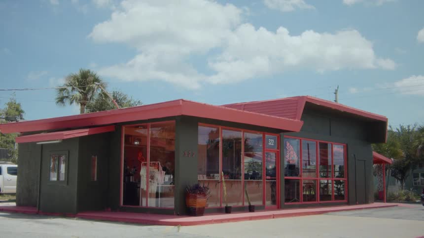 A caf building with a red roof in the city at midday