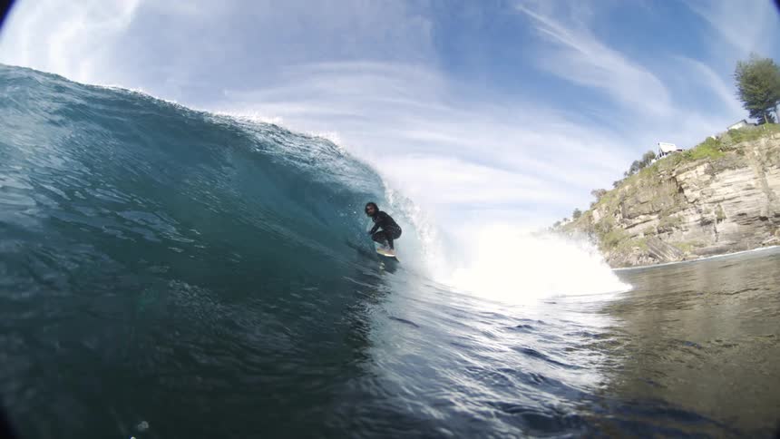 The man rides the wave towards the shore line