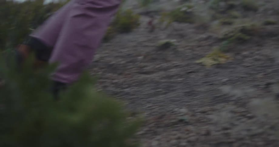 A person walks on a trail in a rocky setting with fog in the foreground