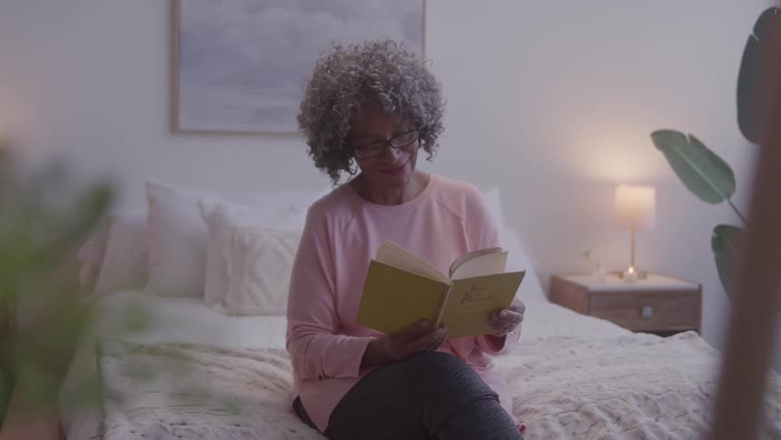 The woman smiles while reading a book